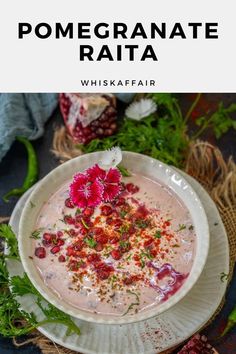 a white bowl filled with soup and garnished with red flowers on the side