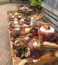 a long table covered with lots of different types of cheeses and meats on it