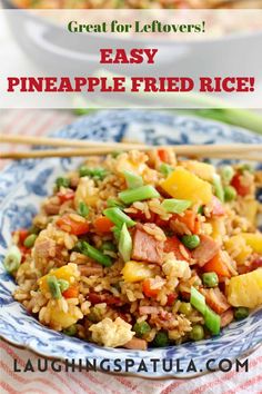 pineapple fried rice in a blue and white bowl with chopsticks on the side