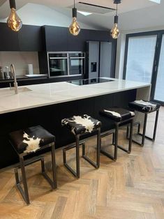 a kitchen with black and white cow hide stools