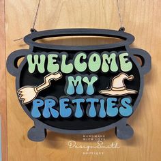 a sign that says welcome my pretties hanging from a door frame on a wooden wall