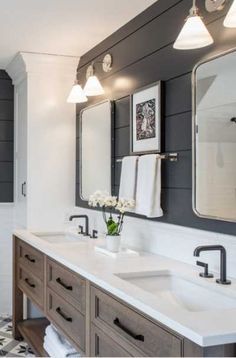 a bathroom with two sinks, mirrors and lights on the wall above them is decorated in black and white checkered tile