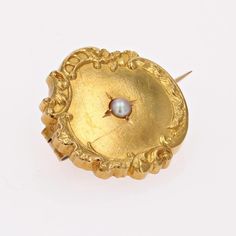 Brooch in 18 karat yellow gold, eagle head hallmark. This round collar brooch in yellow gold is bordered by a floral and arabesque design and features a fine half-pearl in the center. The fastening system is a safety pin. Pearl diameter : 2/2.5 mm approximately. Brooch diameter : 19 mm approximately, thickness : 3 mm approximately. Total weight of the jewel : 2 g approximately. Authentic antique jewel - French work of the 20th Century. Each piece of jewelry is checked and repolished by our Frenc Ornate Engraved Yellow Gold Brooches, Elegant Yellow Gold Baroque Brooches, Elegant Medallion Brooch For Formal Occasions, Ornate Medallion Brooches For Formal Occasions, Ornate Medallion Brooch For Formal Occasions, Ornate Yellow Gold Brooch For Formal Occasions, Elegant Gold Baroque Brooches, Elegant Gold Baroque Brooch, Elegant Yellow Gold Medallion Brooches