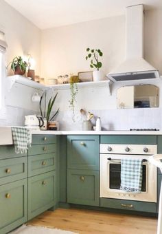 a kitchen with green cabinets and white appliances