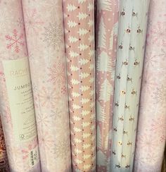 a bunch of wrapping paper sitting on top of a shelf next to eachother