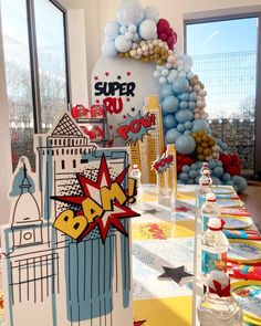 a table set up for a party with balloons and decorations