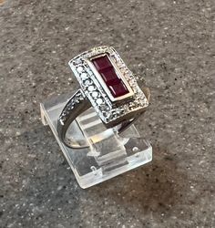 Title: Effy Natural Ruby Diamond 14K White Gold Art Deco Inspired Ring Description: Offering a stunning Art Deco inspired 14K white gold ring by designer Effy. Ring is set with 0.57ct of princess cut natural rubies surrounded by 0.48ct of full cut round brilliant (SI, G-H) diamonds. Gemstones: Rubies (princess cut), Diamonds (full cut round brilliant) Approx. Measurement or Weight of Gem Stones: Rubies: 3 @ 3mm x 3mm x 2.3mm (0.57ct); Diamonds: 32 @ 1.5mm (0.48ct) Color: Rubies: Red, Diamonds: G-H Clarity: SI1-SI2 Mounting metal: 14K white gold Approx. Size or length: Size 5.75, band is 3.5mm wide, design measures 14mm x 8.5mm Condition: Pre owned, very minor wear to metal seen only under 10x magnification, overall excellent condition. Stamping or Factory Markings: 14K and Bita Total weigh 14k White Gold Ruby Ring With Halo Setting, White Gold Ruby Ring With Baguette Cut, Elegant Platinum Ruby Ring With Halo Setting, White Gold Ruby Baguette Cut Ring, Elegant Ruby Ring With Halo Setting In Platinum, Modern White Gold Ruby Ring For Anniversary, Art Deco White Gold Rings Stamped 14k, White Gold Art Deco Rings Stamped 14k, Classic 14k White Gold Ruby Ring