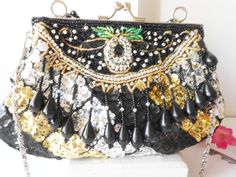 "A glamorous vintage beaded evening bag. Wow, this bag sparkles! The background is black taffeta and it is covered with black, silver and gold sequins and beads. The bag has a silvertone frame and a kiss lock. The interior of the bag is black taffeta and it contains one small pocket. This bag is versatile as it has both a short bead handle plus a chain strap to wear on you shoulder or cross body. This is such a glamorous evening bag. MATERIAL: Beads, sequins, taffeta CONDITION: It is in very goo Black Embellished Pouch Evening Bag, Black Evening Bags With Sequins, Black Sequined Bags For Formal Occasions, Black Sequin Clutch Bag, Black Embellished Evening Bag, Formal Black Bag With Sequins, Formal Black Sequin Bag, Black Evening Bag With Sequins, Black Sequined Evening Clutch Bag