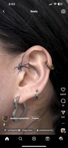 an ear with a spider tattoo on it