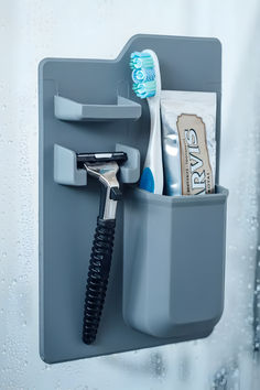 a toothbrush holder with a hairdryer and other items in it on a wall