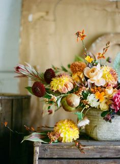 a vase filled with lots of flowers on top of a table