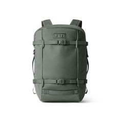 a green backpack with straps on the front and side pockets, sitting against a white background