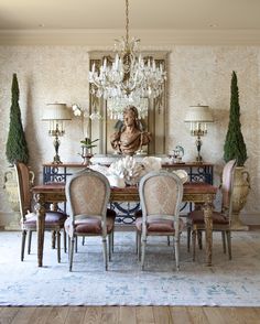 an elegant dining room with chandelier and chairs