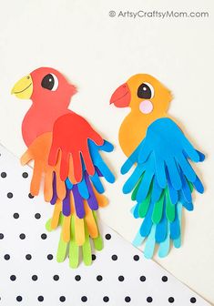 two colorful paper birds sitting next to each other