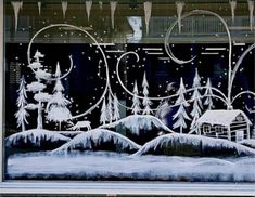 a window decorated with snow and christmas trees