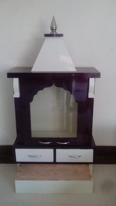 a white and black table with drawers on it's sides in front of a wall