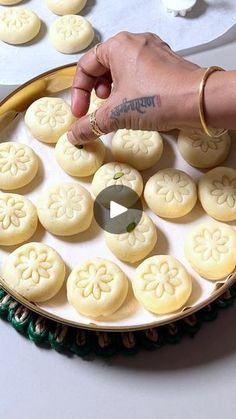 a person is placing cookies on a plate