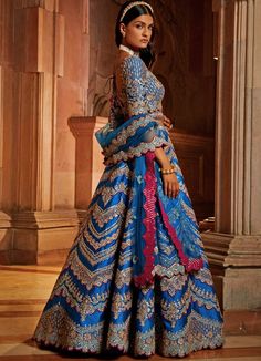 Features the gorgeous peacock blue taffeta lehenga blouse embellished with silver gota, resham and bead work with wine hues. Teamed with a matching blouse and an embellished belt. Completed with tulle dupatta consisting of beautiful gota, resham and beadwork embellishments with a vibrant wine contrast. Composition : Lehenga and Blouse- Taffeta, Dupatta- Tulle Care: Dry Clean Only and Vacuum Storage This product can be customised for sleeves, length of blouse and neckline Delivery : 6-8 weeks as the product is hand crafted. Check Size Guide or choose MySize for free customisation (All Sizes above XL can be made at 15% additional cost) For more information and sizes please contact fabiliciousfashion@gmail.com or visit our Copenhagen studio.About the Designer : Nikita Gujral’s collection of b Blue Chandbali Lehenga For Eid, Blue Tissue Silk Sharara For Navratri, Festive Blue Chandbali Choli, Traditional Blue Tissue Silk Sets, Fitted Blue Tissue Silk Choli, Anarkali Blue Tissue Silk Set, Blue Silk Embellished Lehenga, Blue Tissue Silk Lehenga For Navratri, Blue Tissue Silk Choli For Designer Wear