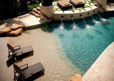 an outdoor swimming pool with lounge chairs next to it