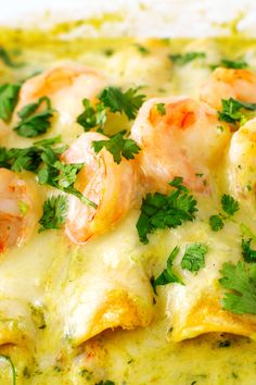 a close up of food on a plate with broccoli and shrimp in sauce