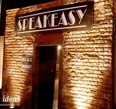 the entrance to speakeasy is lit up at night, with brick walls and doors