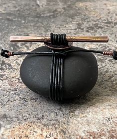 a small black rock with two sticks attached to it