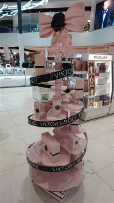 a display in a store with pink boxes stacked on top of each other and ribbons tied around them