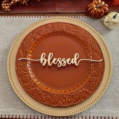 a chocolate cake with the word messed on it sitting on a table next to pumpkins