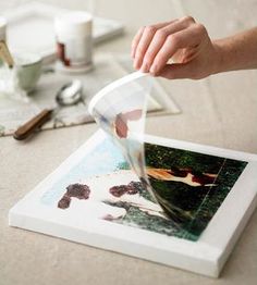 a person's hand reaching for an image on a table