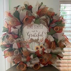 a wreath that says live simply and be grateful