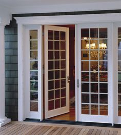 an open french door with glass panels and chandelier