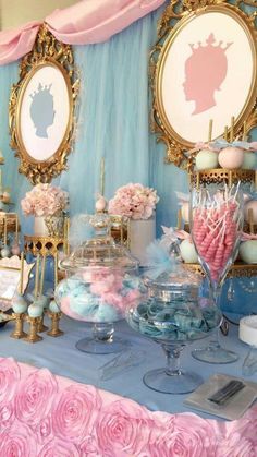 a table topped with lots of candy and candies next to pictures on the wall