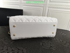 a white purse sitting on top of a table next to a black and white box