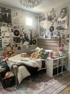 a bed room with a neatly made bed and lots of pictures on the wall