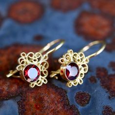 Contessa Earrings: $55+. Choose from pearl, jade, iolite, garnet (shown), onyx, peridot, amethyst, or moonstone crowned with arabesques of filigree to make a showy pair of earrings. 24k gold over sterling silver; hinged backs. 3/4 Inch tall. Ornate Garnet Filigree Jewelry, Ornate Filigree Garnet Jewelry, Elegant Gold Jewelry With Garnet, Elegant Gold Garnet Jewelry, Handmade Elegant Garnet Earrings, Elegant Handmade Garnet Earrings, Elegant Garnet Earrings, Elegant Gold Garnet Earrings, Elegant Pierced Garnet Earrings