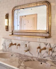 a bathroom vanity with two sinks and a large mirror