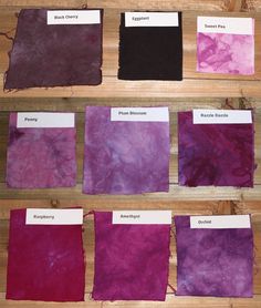 several different shades of purple and black on a wooden surface with labels in each section