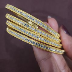 "* Handcrafted Gold Plated 4 Bangle Set. Sold as a set. * Bangles with high quality CZ stones. * High Quality 22K Gold Plated. Bangles Sizes : 2.4 inches= ( 2.25\" diameter of the inner circle) ; 2.6 inches = ( 2.39\" diameter of the inner circle); 2.8 inches = (2.54\" diameter of the inner circle) The gorgeous gold-plated bangles set best exemplifies the careful craftsmanship done on it -- specially picked for you by Nemali Jewelry. It has a special tone of elegance attached to it. The intricat Gold Adjustable Bridal Sets, Adjustable Gold Bridal Sets, Gold Bling Bangle Gift, Gold Sparkling Bangle Bracelets, Gold Sparkling Bangle Bracelet, Sparkling Gold Jewelry For Festive Occasions, Festive Sparkling Gold Jewelry, Gold Bracelets With Stone Work For Anniversary, Dazzling Gold Jewelry With Stone Work