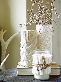 two white vases sitting on top of a table next to each other with flowers in them