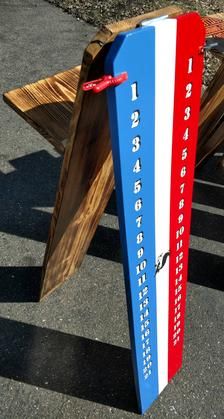 a wooden bench sitting on the side of a road next to a sign that says 1, 2, 4, 5