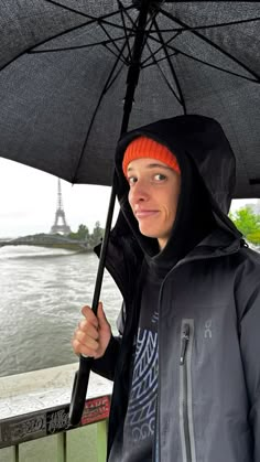 a man holding an umbrella over his head near the eiffel tower in paris