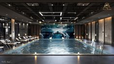 an indoor swimming pool with chairs around it and a large screen on the wall behind it