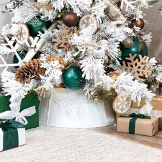 a white christmas tree with green and gold ornaments