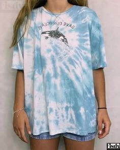 a girl wearing a blue and white tie dye shirt with a dolphin on the front