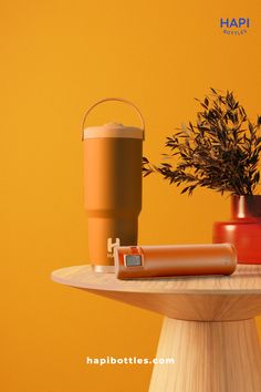 a table topped with a coffee cup and a vase filled with plants on top of it