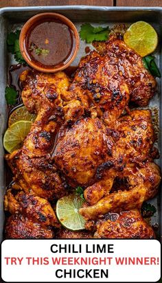 grilled chicken with limes and ketchup in a pan on a wooden table