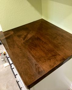 a kitchen counter top in the middle of being painted white and brown with green walls