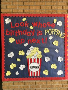 a sign that says, look who's birthday is popping up next to popcorn