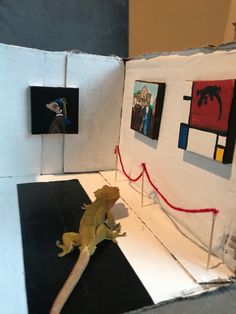 a gecko sitting on top of a piece of cardboard