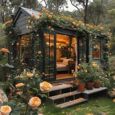 a small house with lots of flowers growing on it